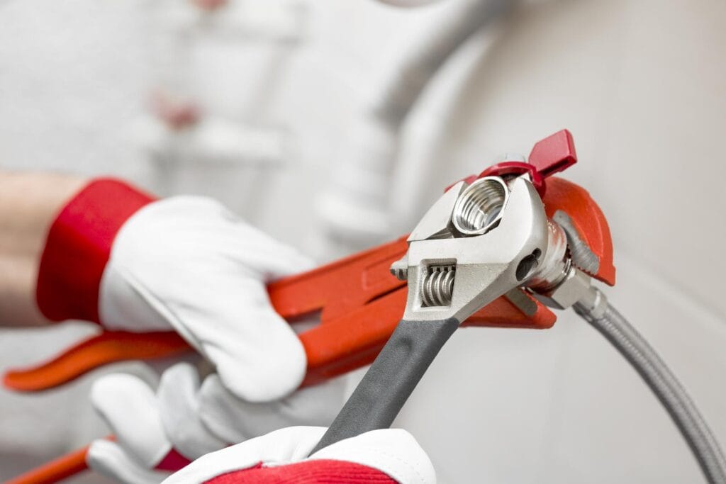 Plumber holding pipe wrenches for an emergency repair in Smyrna