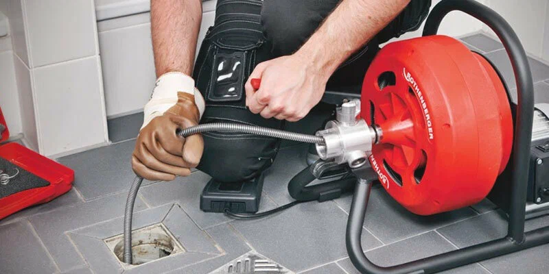 Plumber using a drain-cleaning machine in Smyrna