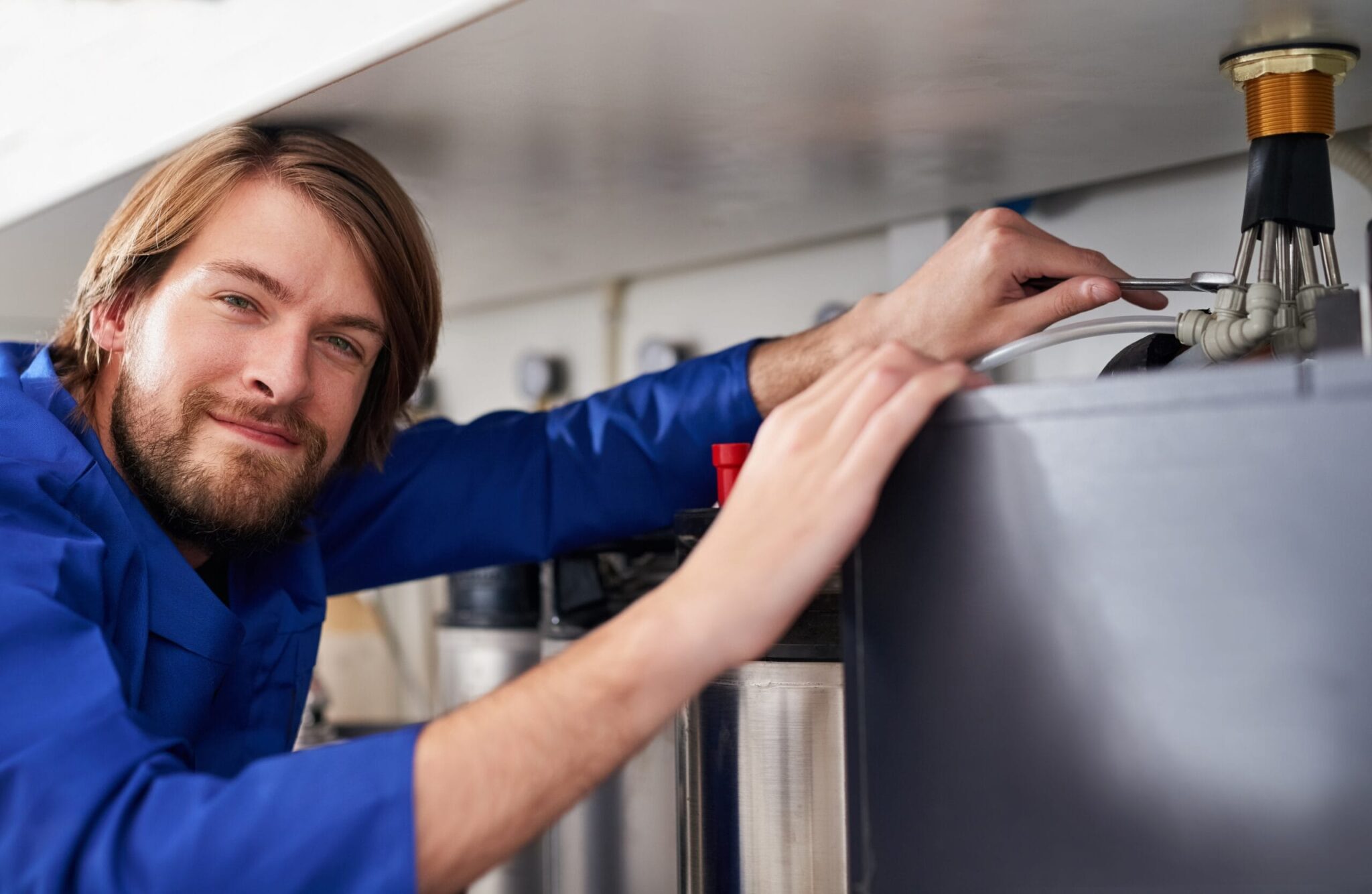 Technician servicing a residential water heater tank in Smyrna